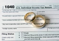 Wedding rings on top of a tax return filed by a divorced couple.