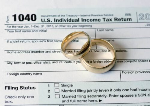 Wedding rings on top of a tax return filed by a divorced couple.