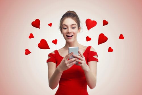 Cute young woman texting on the phone, with red hearts flying