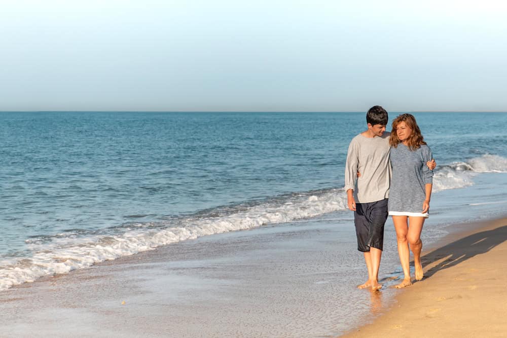 Mother and son talking and walking on the beach