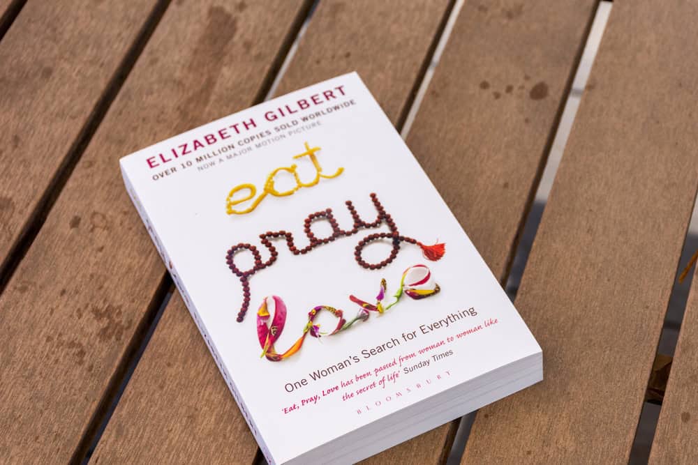 The American author Elizabeth Gilbert's "Eat, Pray, Love" book on a wooden table