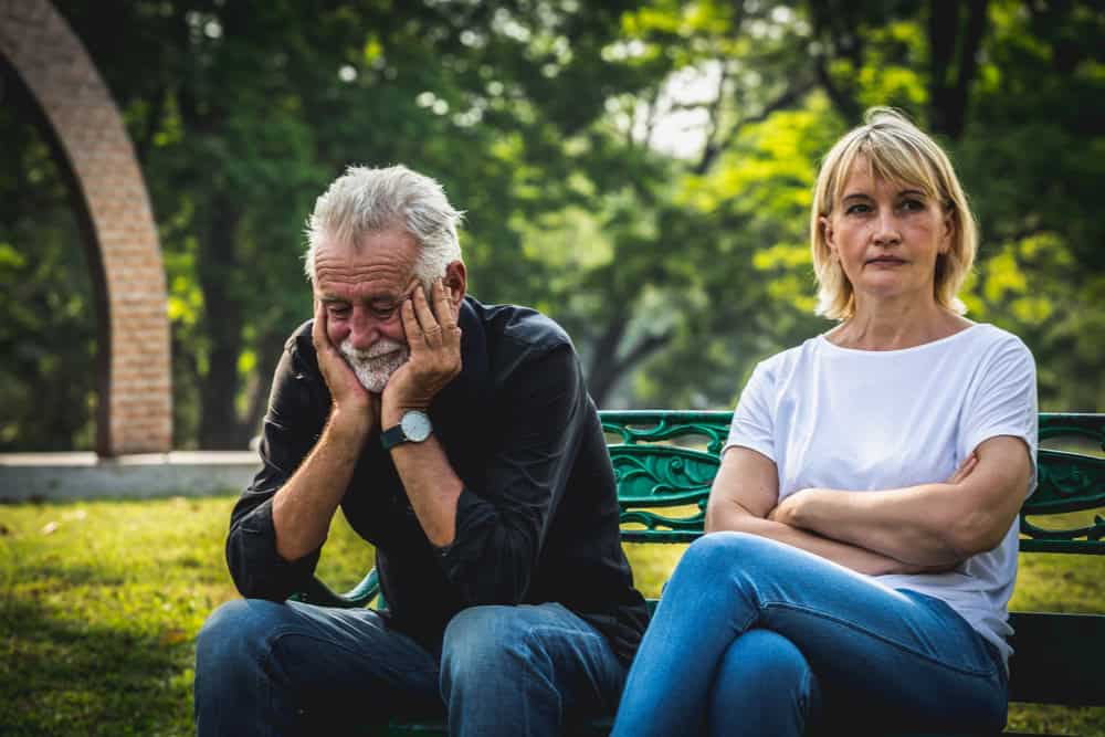 senior couple sitting on bench in the park background, Making decision of breaking up get divorced,